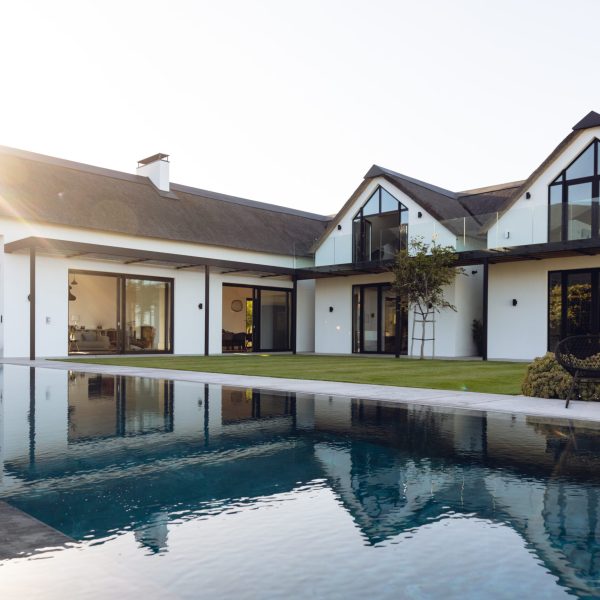 View of luxurious modern house exterior with garden and swimming pool. Modern architecture and designing concept